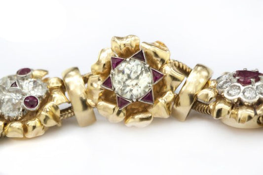 Vintage 7ct Diamond and Ruby Cluster Bracelet; set with 7.00 carats of diamonds and 3.00 carats of rubies in intricate and unique floral clusters surrounded by gold leaves, in 18ct yellow gold, Circa 1930s