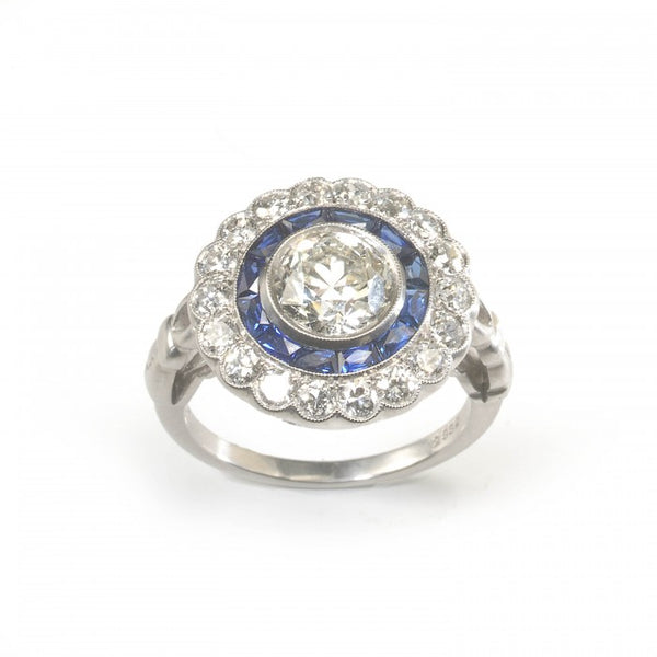 Art Deco Style Diamond and Sapphire Target Cluster Ring; 1.40ct round European old-cut diamond surrounded by twelve French-cut sapphires and an outer border of 0.93cts brilliant-cut diamonds, in platinum