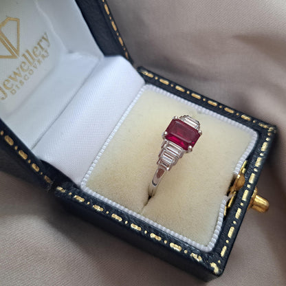 1ct Burma Ruby and Baguette Diamond Engagement Ring, 1.07ct emerald-cut Burmese ruby flanked with graduated stepped baguette-cut diamonds in platinum