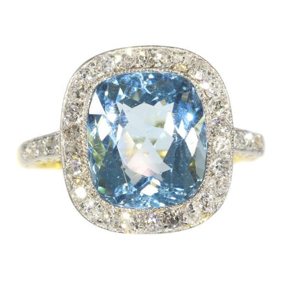 Vintage Aquamarine and Diamond Cluster Ring; central 4.17ct cushion-cut aquamarine surrounded by 0.52cts old-cut diamonds, in platinum and 18ct yellow gold, Circa 1920