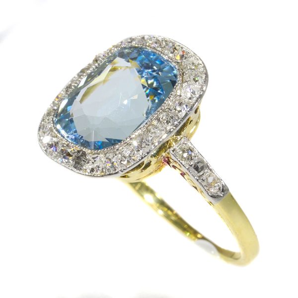 Vintage Aquamarine and Diamond Cluster Ring; central 4.17ct cushion-cut aquamarine surrounded by 0.52cts old-cut diamonds, in platinum and 18ct yellow gold, Circa 1920