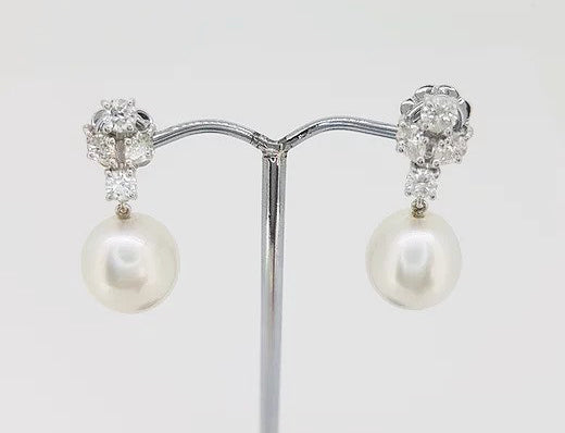 South Sea Pearl and Diamond Drop Earrings; featuring 11mm white South Sea pearls suspended from 1.16cts diamond clusters, in 18ct white gold