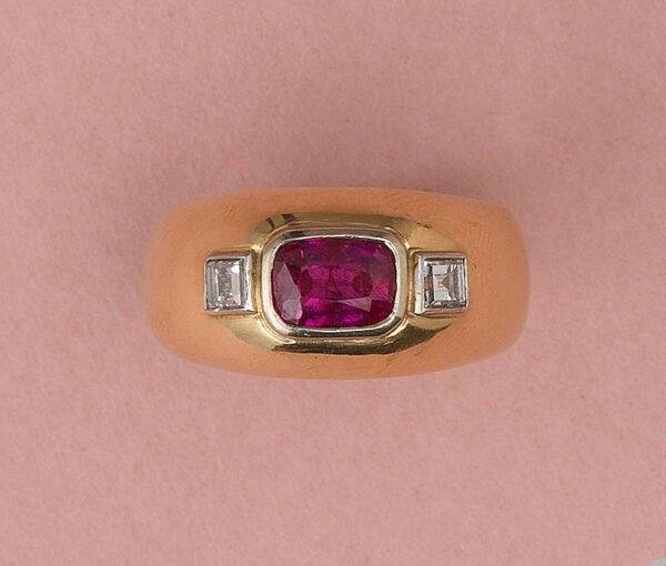Vintage French Ruby and Diamond Three Stone Dress Ring in 18ct Yellow Gold; 1.68ct table cut unheated ruby flanked by carré cut diamonds, Circa 1950s-1970s
