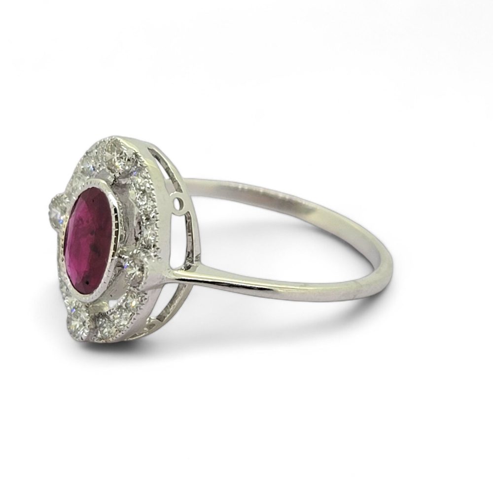 Ruby and Diamond Halo Cluster Engagement Ring, 0.70ct oval red ruby surrounded by fixed halo of diamonds with larger diamonds at the four compass points in 18ct white gold