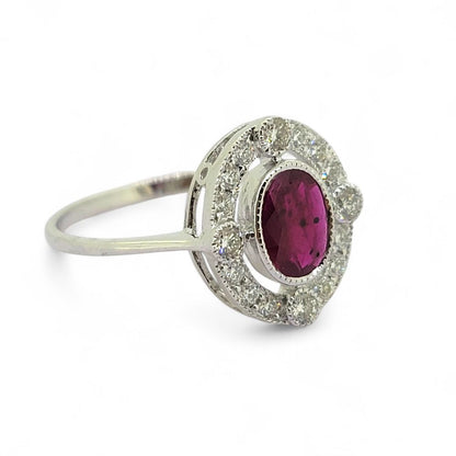 Ruby and Diamond Halo Cluster Engagement Ring, 0.70ct oval red ruby surrounded by fixed halo of diamonds with larger diamonds at the four compass points in 18ct white gold