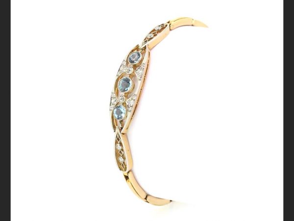 Edwardian Aquamarine and Diamond Panel Bracelet; Three round cut aquamarines accentuated by round cut diamonds, expanding strap, c.1910, 15ct gold
