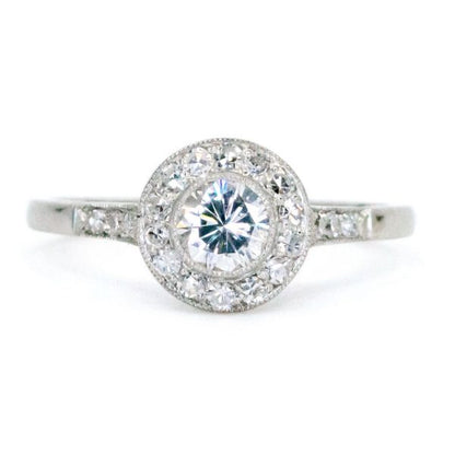 This lovely engagement vintage Art Deco revivalist design ring features a 0.40ct (H SI1) brilliant cut diamond decorated with 0.25ct single cut diamonds crafted in platinum.