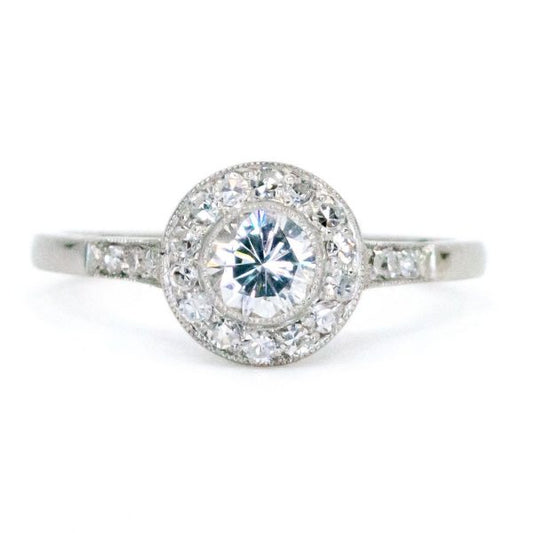 This lovely engagement vintage Art Deco revivalist design ring features a 0.40ct (H SI1) brilliant cut diamond decorated with 0.25ct single cut diamonds crafted in platinum.