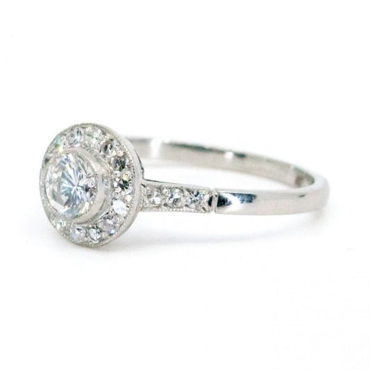This lovely engagement vintage Art Deco revivalist design ring features a 0.40ct (H SI1) brilliant cut diamond decorated with 0.25ct single cut diamonds crafted in platinum.