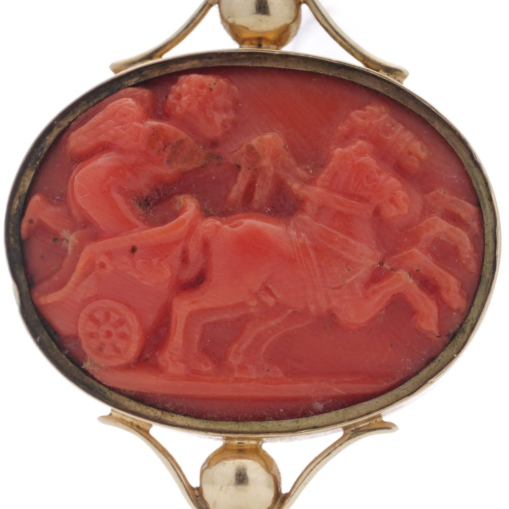 Victorian pocket watch key/pendant in gold and carved coral showing neoclassical scenes.