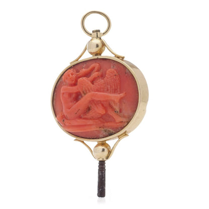 Victorian pocket watch key/pendant in gold and carved coral showing neoclassical scenes.
