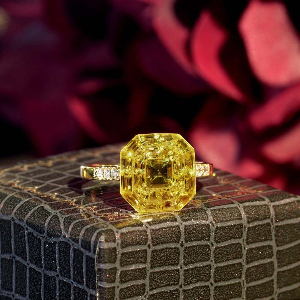 Yellow Sapphire Octagonal Cluster Solitaire Engagement Ring, 5.27cts yellow sapphires arranged in an invisible setting to produce an octagonal shaped design in 14ct yellow gold with diamond set shoulders
