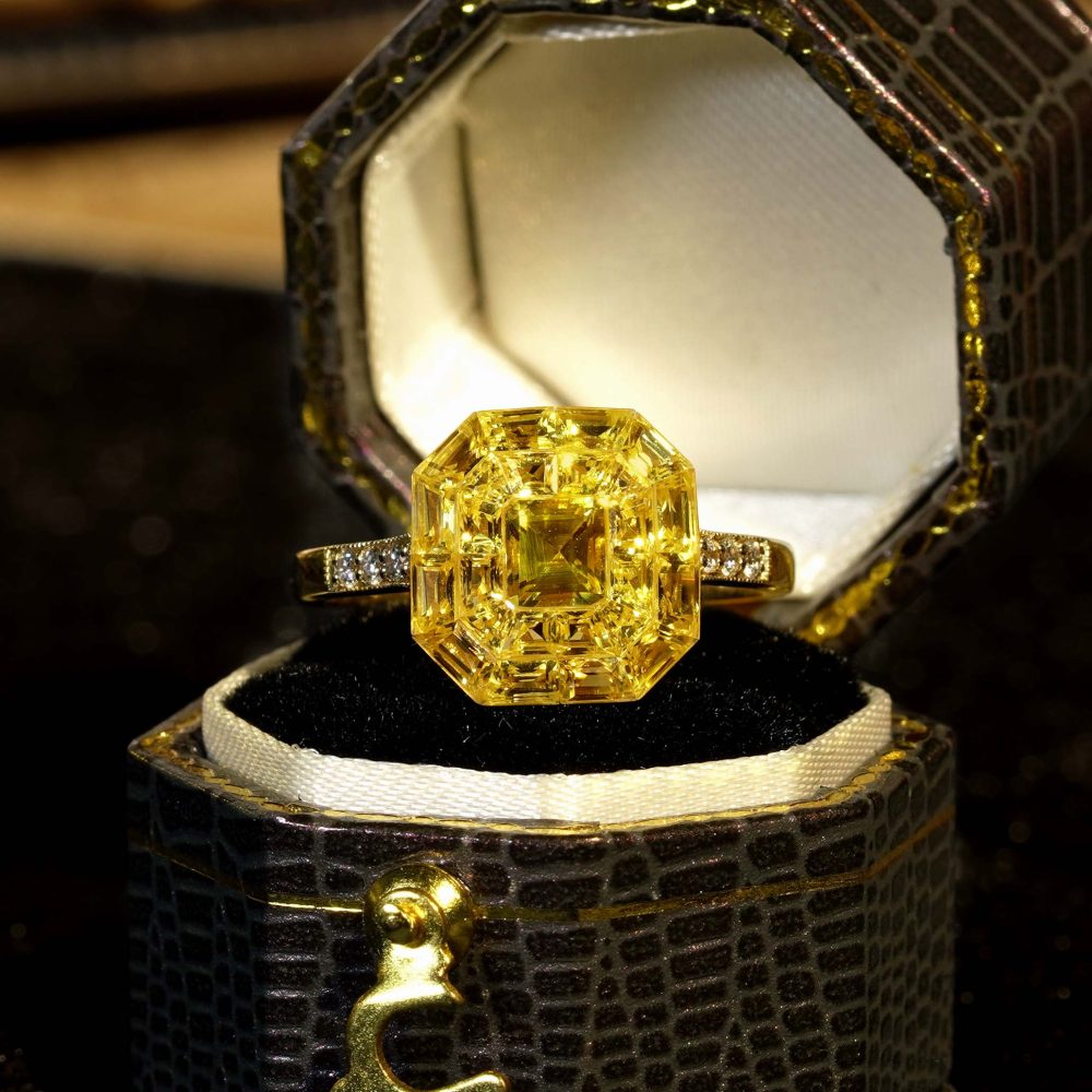 Yellow Sapphire Octagonal Cluster Solitaire Engagement Ring, 5.27cts yellow sapphires arranged in an invisible setting to produce an octagonal shaped design in 14ct yellow gold with diamond set shoulders