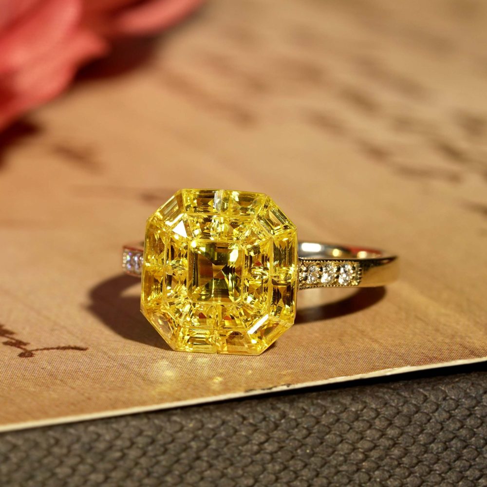 Yellow Sapphire Octagonal Cluster Solitaire Engagement Ring, 5.27cts yellow sapphires arranged in an invisible setting to produce an octagonal shaped design in 14ct yellow gold with diamond set shoulders