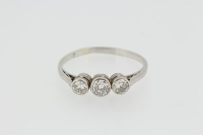 Three Stone Diamond Ring in 18ct White Gold; An elegant diamond trilogy ring featuring three collet set diamonds in 18ct white gold