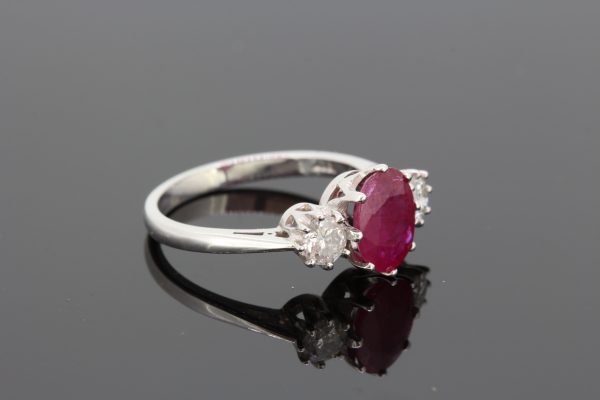 Ruby and Diamond Three Stone Ring; 1.90 carat oval faceted ruby flanked by 0.50cts round brilliant-cut diamonds, claw set in 18ct white gold