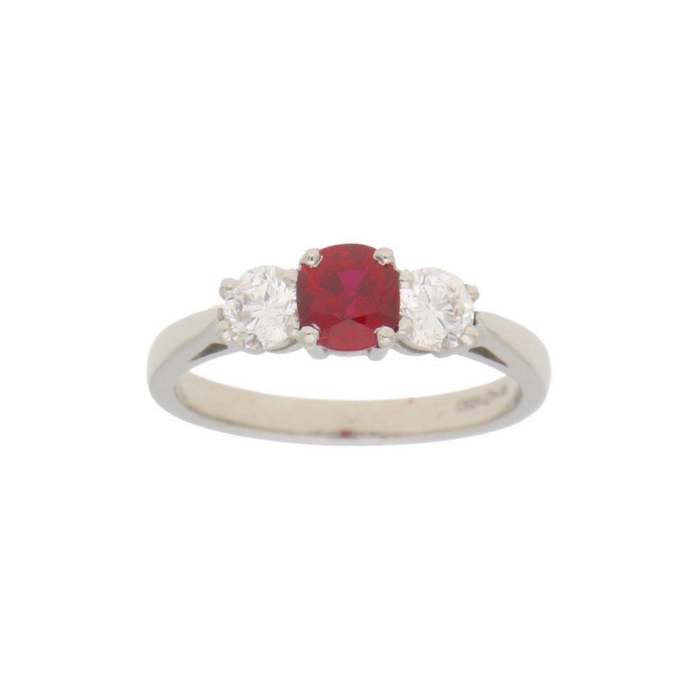 0.98ct Ruby and Diamond Trilogy Engagement Ring; central 0.98ct cushion-cut ruby flanked by 0.62cts brilliant-cut diamonds in 18ct white gold